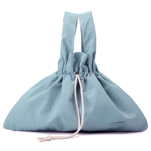 Detail of grey-blue nylon handbag featuring a drawstring closure and cream cotton rope handles