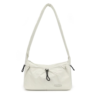 Detailed macro of the water-resistant nylon fabric texture and drawstring on the cream bag