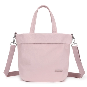 Close-up of light pink nylon shoulder bag showing detachable wide strap and brand logo