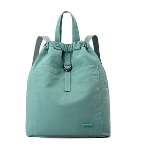 Detail eines hellgrünen Nylon-Rucksacks mit Kordelzugverschluss und Markenlabel