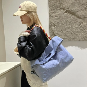 Détail du sac fourre-tout bleu clair avec bandoulière tissée sur un mannequin