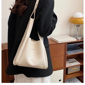 Close-up of beige leather bucket bag with JZBAG embossed logo and pebbled texture