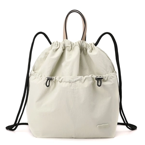 Detail of minimalist beige drawstring backpack showing nylon texture and brand logo