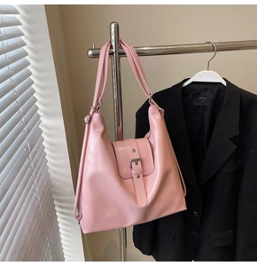 Détail d'un sac hobo rose brillant avec une grande capacité et des boucles en métal
