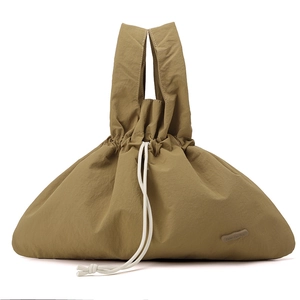 Detail of khaki water-resistant nylon handbag with drawstring closure and logo