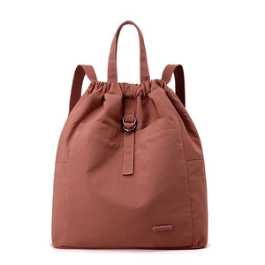 Detail eines ziegelroten Nylon-Rucksacks mit Kordelzug und wasserfester Textur