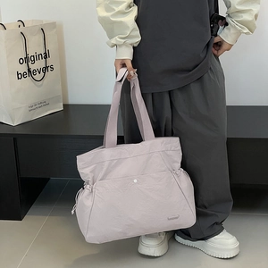 Detailansicht der hellvioletten Nylon-Tragetasche mit Druckknopftasche und Kordelzug-Akzenten