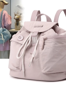 Pink nylon backpack with buckle closure and side pockets shown in a soft lifestyle setting