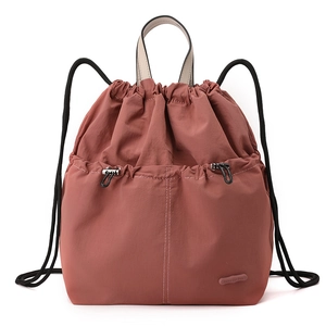 Detail of dusty pink drawstring backpack featuring nylon fabric and adjustable front pocket