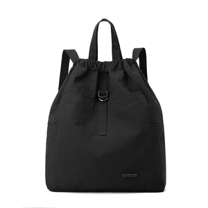 Detailansicht eines schwarzen Nylon-Rucksacks mit D-Ring und kleinem Markenlogo-Patch