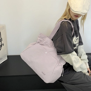 Detailansicht der lila Nylon-Tragetasche mit Kordelzug und breitem Schultergurt