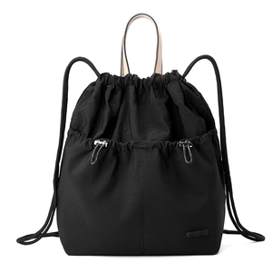 Detailed view of black nylon drawstring backpack with light leather handle and texture