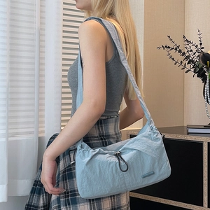 Light blue nylon cloud bag with pleated texture and adjustable drawstring on female model