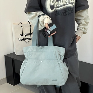 Details der hellgrünen Nylontasche mit seitlichem Kordelzug und metallischem Druckknopf