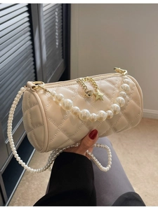 Quilted cream cylinder crossbody bag with pearl chain straps and gold star zipper detail