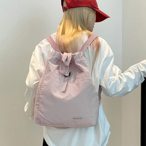 Seitenansicht des leichten hellrosa Nylon-Rucksacks mit Kordelzug und praktischen Seitentaschen