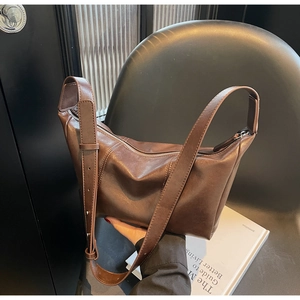Detailed close-up of dark brown matte hobo bag with vertical stitching and wide strap