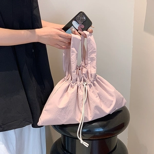 Detail view of light pink drawstring handbag with pleated nylon fabric and cloud shape