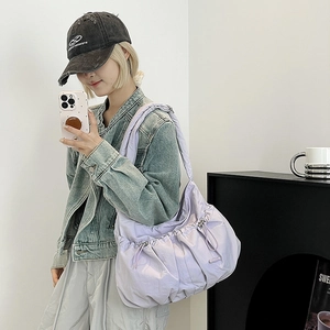 Detail of light purple pleated nylon crossbody bag showing drawstring texture and adjustable strap