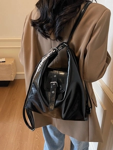 Sac fourre-tout minimaliste en cuir verni noir avec foulard porté par un mannequin