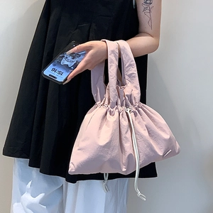 Close-up of pink nylon handbag with white cotton drawstrings and water-resistant fabric