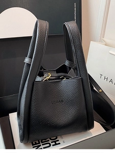 Elegant black pebbled leather bucket bag with gold hardware and long shoulder strap
