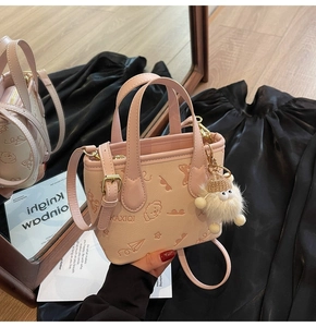 Detail of pink mini bucket bag with cartoon embossing and cute plush monster charm