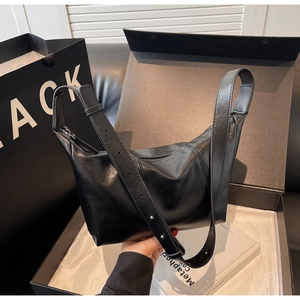Close-up of black PU leather hobo bag with adjustable strap and polished metal hardware