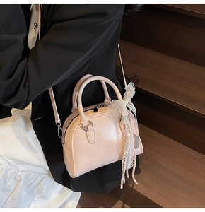 Detail of light pink mini bowling bag with white lace bow on wood staircase