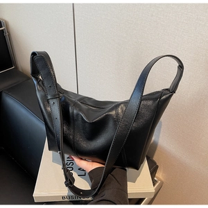 Close-up of black crescent moon shoulder bag featuring a pebbled leather texture detail