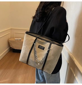 Détail du sac cabas beige texturé avec chaîne argentée et finitions noires