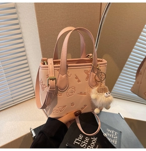 Detailed relief pattern of cartoon dogs and butterflies on a light pink PU leather bucket bag