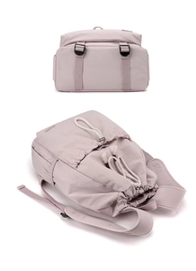 Detail view of light purple nylon backpack featuring drawstring closure and buckle