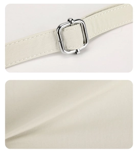 Close-up of off-white canvas texture and adjustable silver metal buckle on a shoulder strap