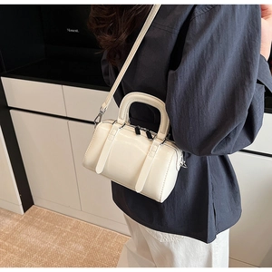 Detail view of the glossy white Boston bag with silver zippers and hand strap