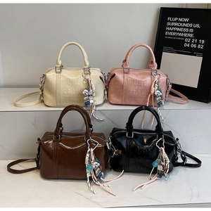 Detail view of four colorful Boston bags with dog charms and embossed lettering