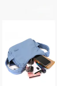 Detail showing a blue pleated dumpling bag with large capacity for daily essentials