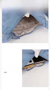 Detail view of the light blue nylon crossbody bag interior with multiple zipper pockets