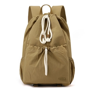 Front detail of khaki nylon drawstring backpack with cotton ropes and large front pocket
