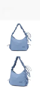 Detail view of blue nylon crescent bag with drawstring straps and side pocket accents
