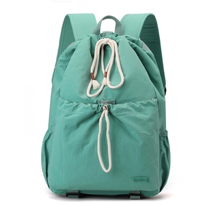 Detail shot of mint green nylon drawstring backpack showing water-resistant texture