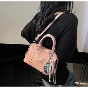 Detail of pink Boston bag with Cheerful Time embossing and decorative pendant charm