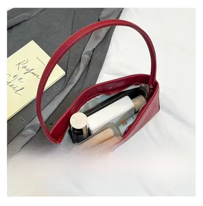 Spacious interior of red leather handbag showing storage capacity for phone and perfume