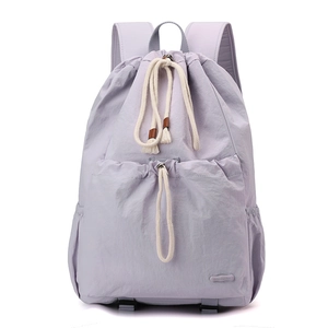 Detailed close-up of light purple nylon drawstring backpack with front pocket and side pouch