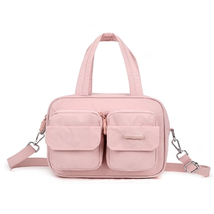 Detail of pink waterproof nylon crossbody bag featuring double front flap pockets