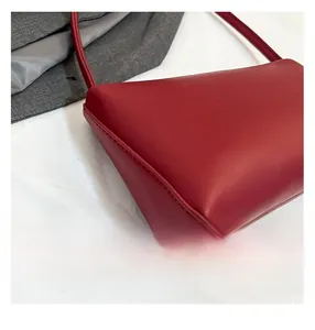 Detail view of precise stitching on the burgundy leather shoulder bag with matte finish