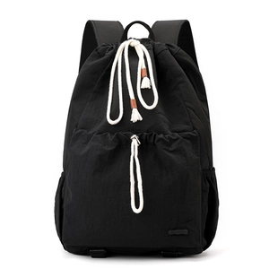 Detail of black nylon drawstring backpack with white cotton ropes and leather trim tips