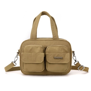 Detail of multi-pocket khaki nylon crossbody bag showing zippers and brand logo tag
