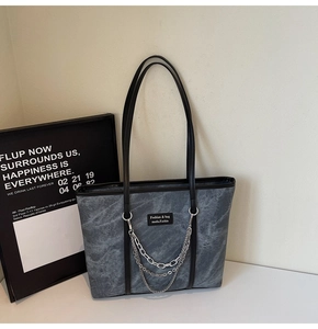 Détail du cabas gris texture marbre avec chaînes argentées et étiquette de marque