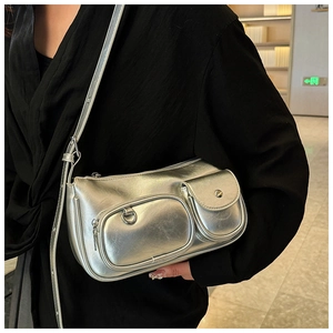 Detail of silver metallic square shoulder bag with adjustable strap and front pockets